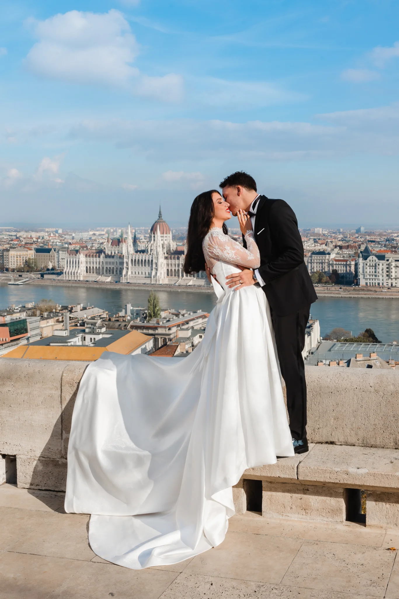Elegáns esküvői ruha próba egy stílusos bálteremben Budapest belvárosában, menyasszonyi ruhák között.