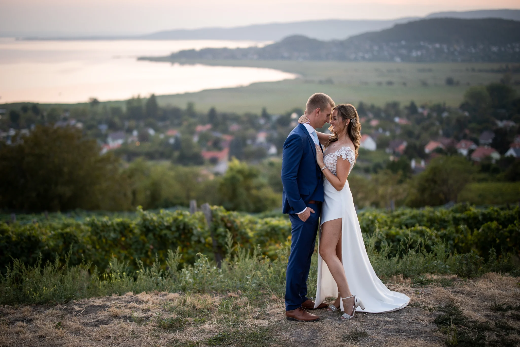 Egy elegáns menyasszony próbálja az esküvői ruhát, amely tökéletesen kiemeli alakját a próbafülkében
