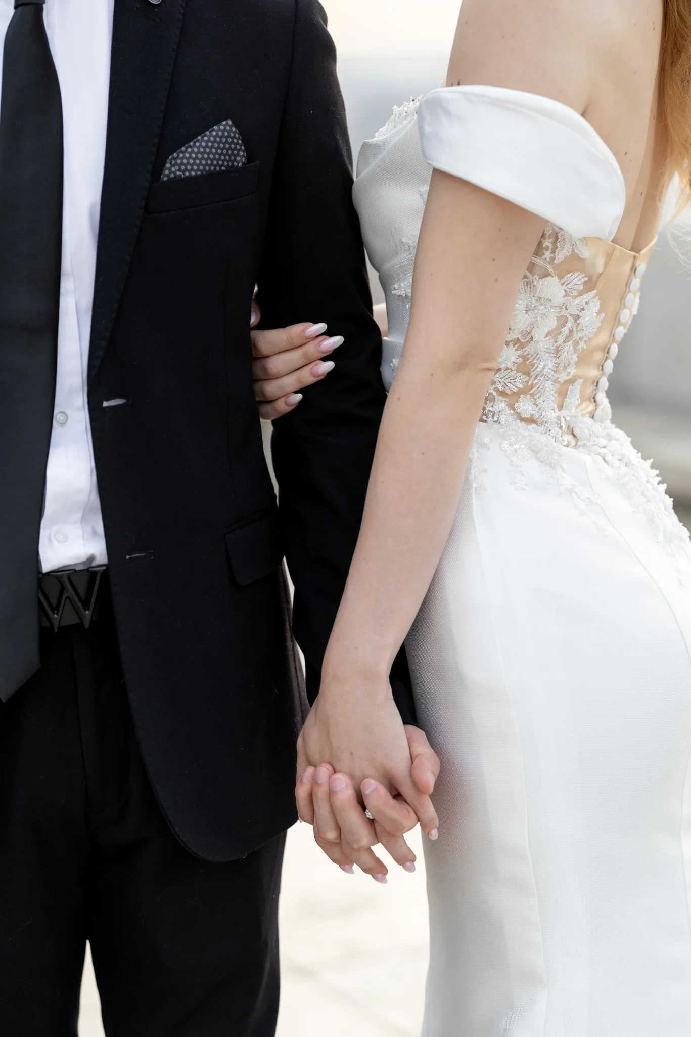 Egy elegáns olasz stílusú menyasszonyi ruha finom csipkével és díszes szegéllyel, menyasszonyi csokorral kiegészítve